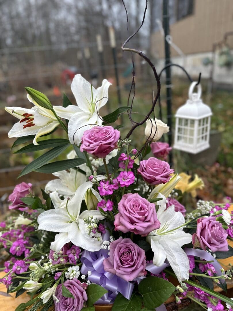 A bouquet of flowers in the foreground with a lantern hanging from a pole.